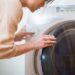 洗濯機の洗濯物を入れている女性
